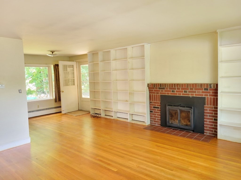 38 Bigelow Road Lancaster, MA 01523 - Photo 10 of 26 an empty room with a fireplace and windows