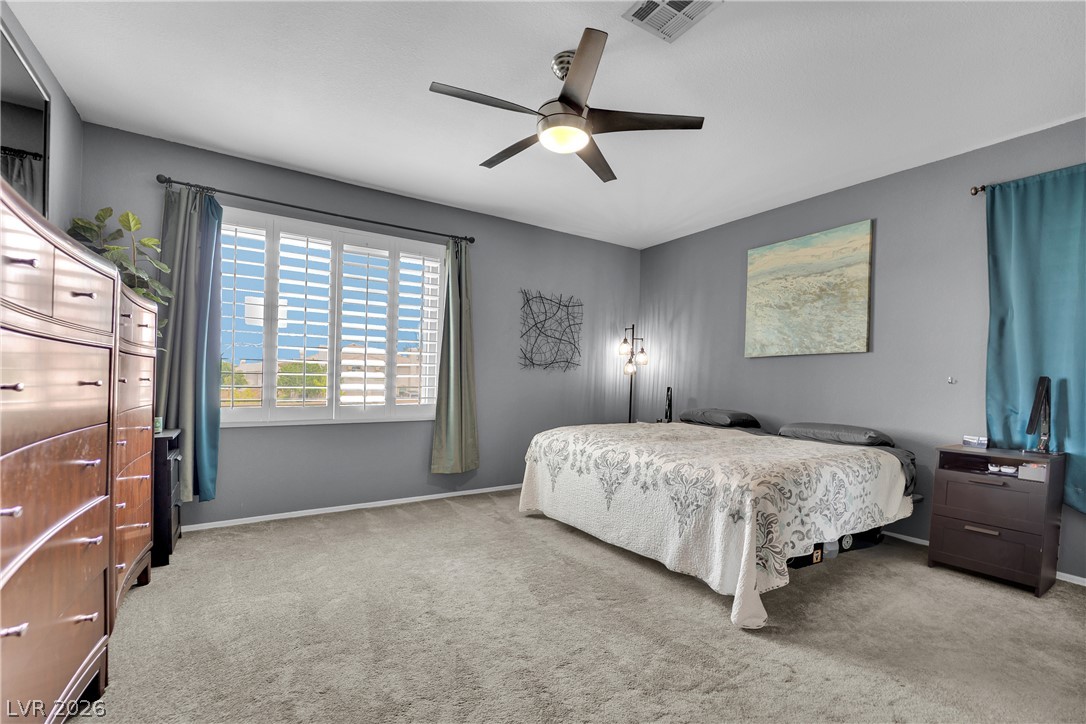 1724 Millstream Way Henderson, NV 89074 - Photo 27 of 60 Well-lit sleeping quarters featuring carpeted floors and a prominent ceiling fan.