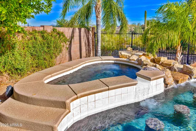 a living room with furniture a flat screen tv and a chandelier