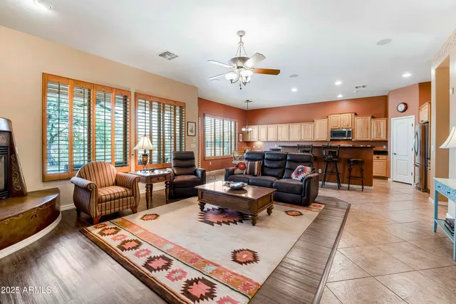 a living room with furniture kitchen view and a large window