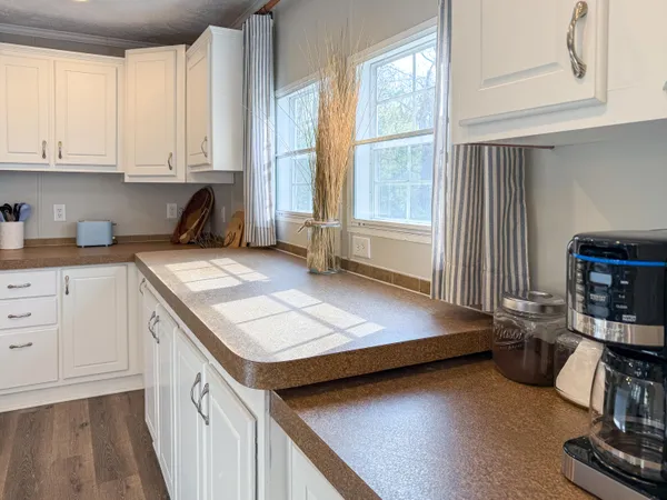 a kitchen with a sink a stove and white cabinets