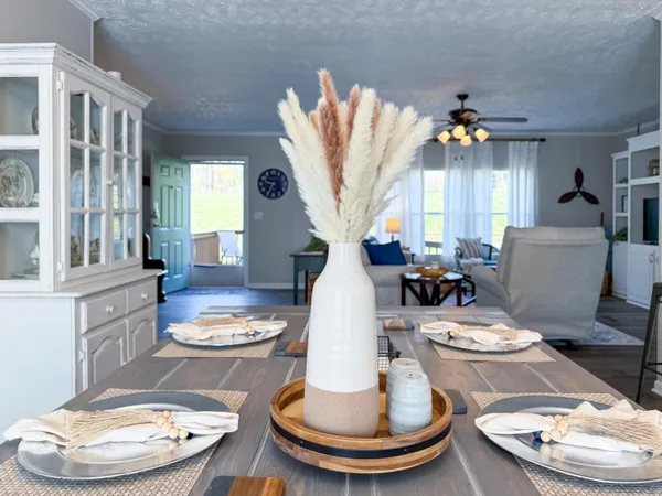 a view of a dining room with furniture a fireplace and wooden floor