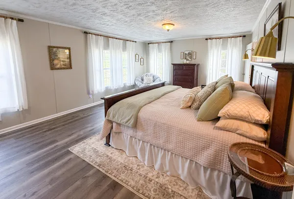 a bedroom with a bed a couch and dresser