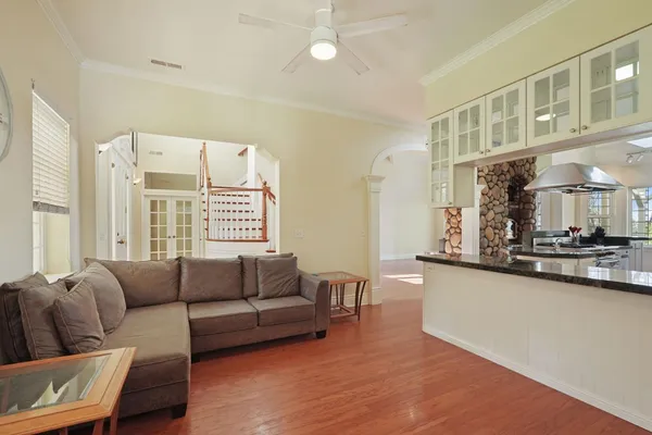a kitchen with stainless steel appliances granite countertop a sink a stove and a wooden floors