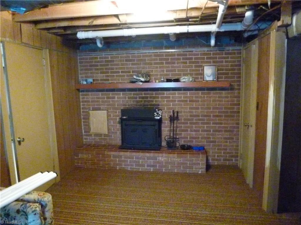 1476 Barker Road Roaring River, NC 28669 - Photo 29 of 29 Basement room with fireplace, bathroom with shower, sink and toilet. Picture taken near fireplace; room is much bigger. Needs ceiling, paint and updating. NOT included in main square footage.