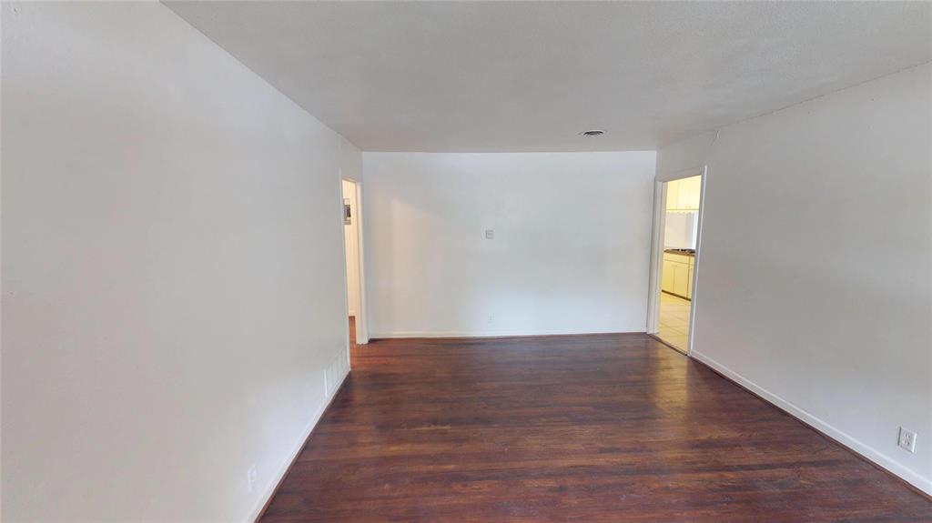 1705 Crescent Street Denton, TX 76201 - Photo 6 of 7 a view of an empty room with wooden floor and a window