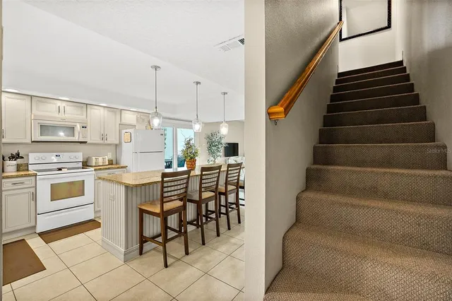 a kitchen with stainless steel appliances kitchen island granite countertop furniture and a view of living room