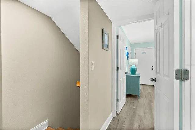 a view of a hallway with closet and wooden floor