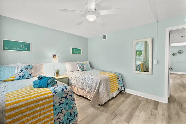 a bedroom with two beds and a chandelier