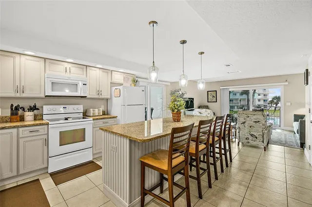 a kitchen with appliances cabinets and chairs