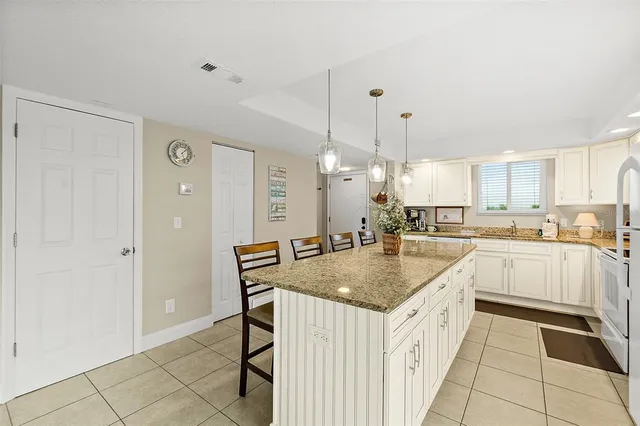 a kitchen with appliances cabinets and chair