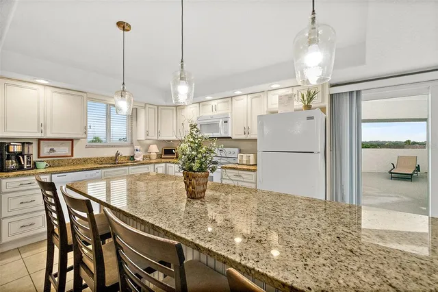 a kitchen with stainless steel appliances granite countertop sink refrigerator and cabinets