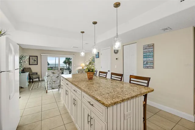 a kitchen with stainless steel appliances granite countertop a sink a counter space and a chandelier
