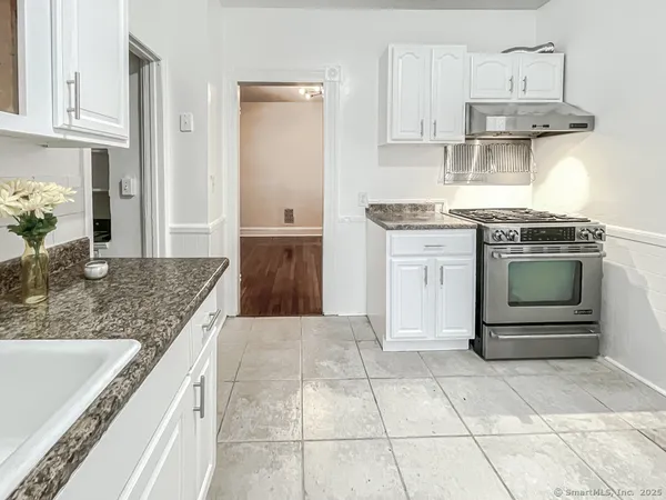 a kitchen with stainless steel appliances granite countertop a stove a sink and a granite counter tops