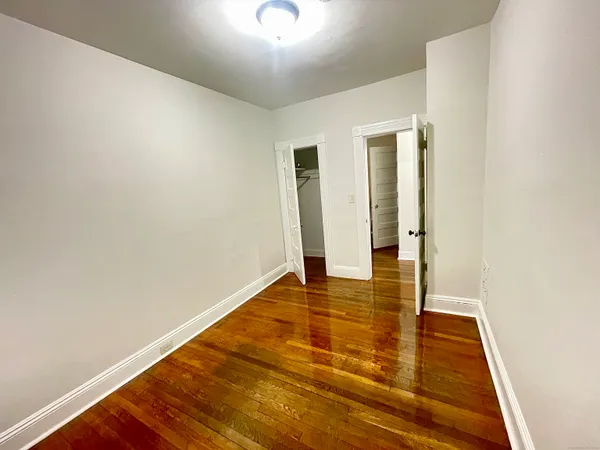 a view of an empty room with wooden floor
