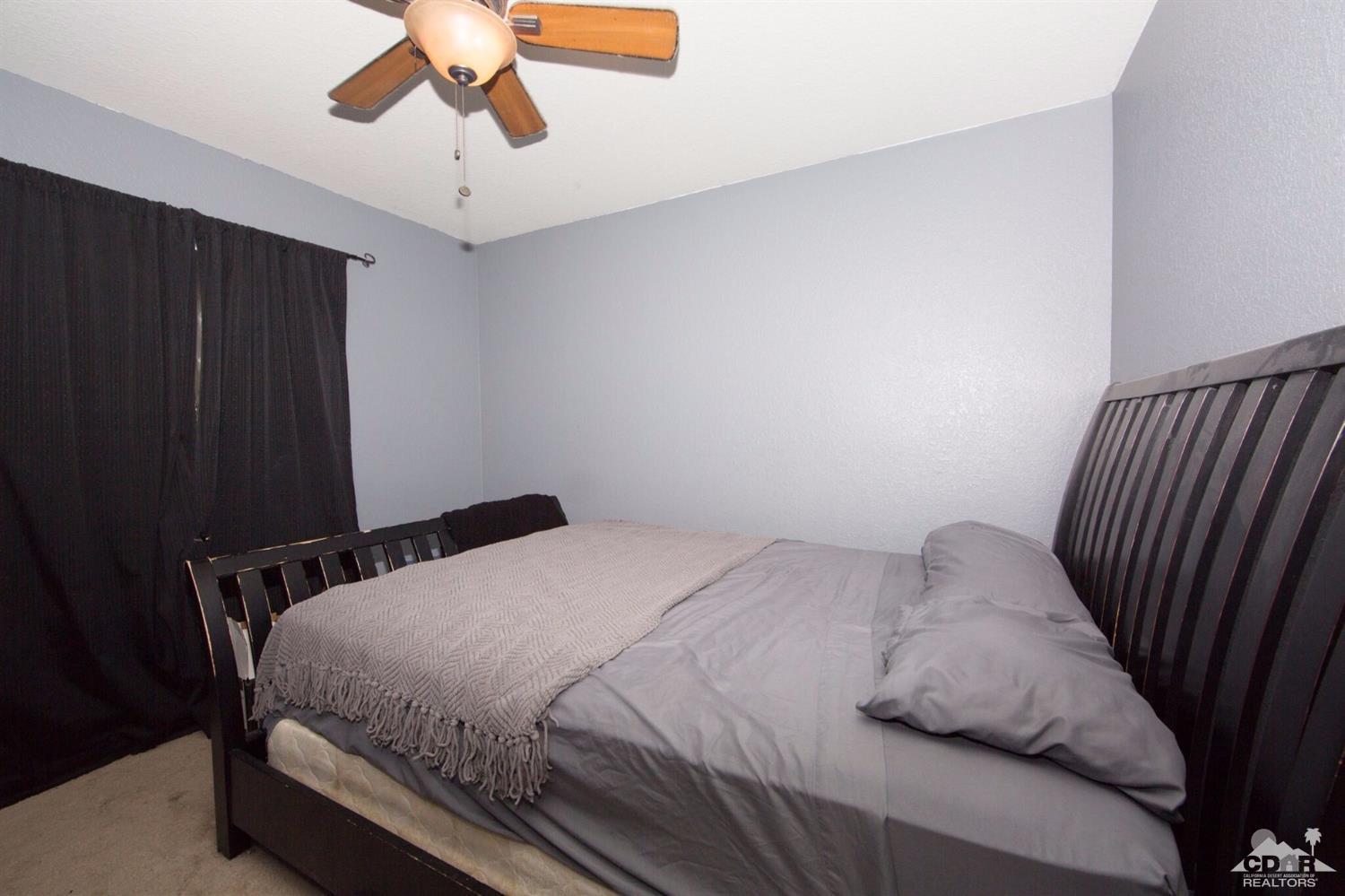 83948 Pacifica Sur Indio, CA 92203 - Photo 12 of 16 a bedroom with a bed and painting on the wall