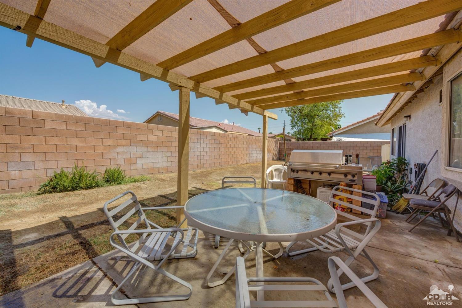 83948 Pacifica Sur Indio, CA 92203 - Photo 14 of 16 a table and chairs in front of a building