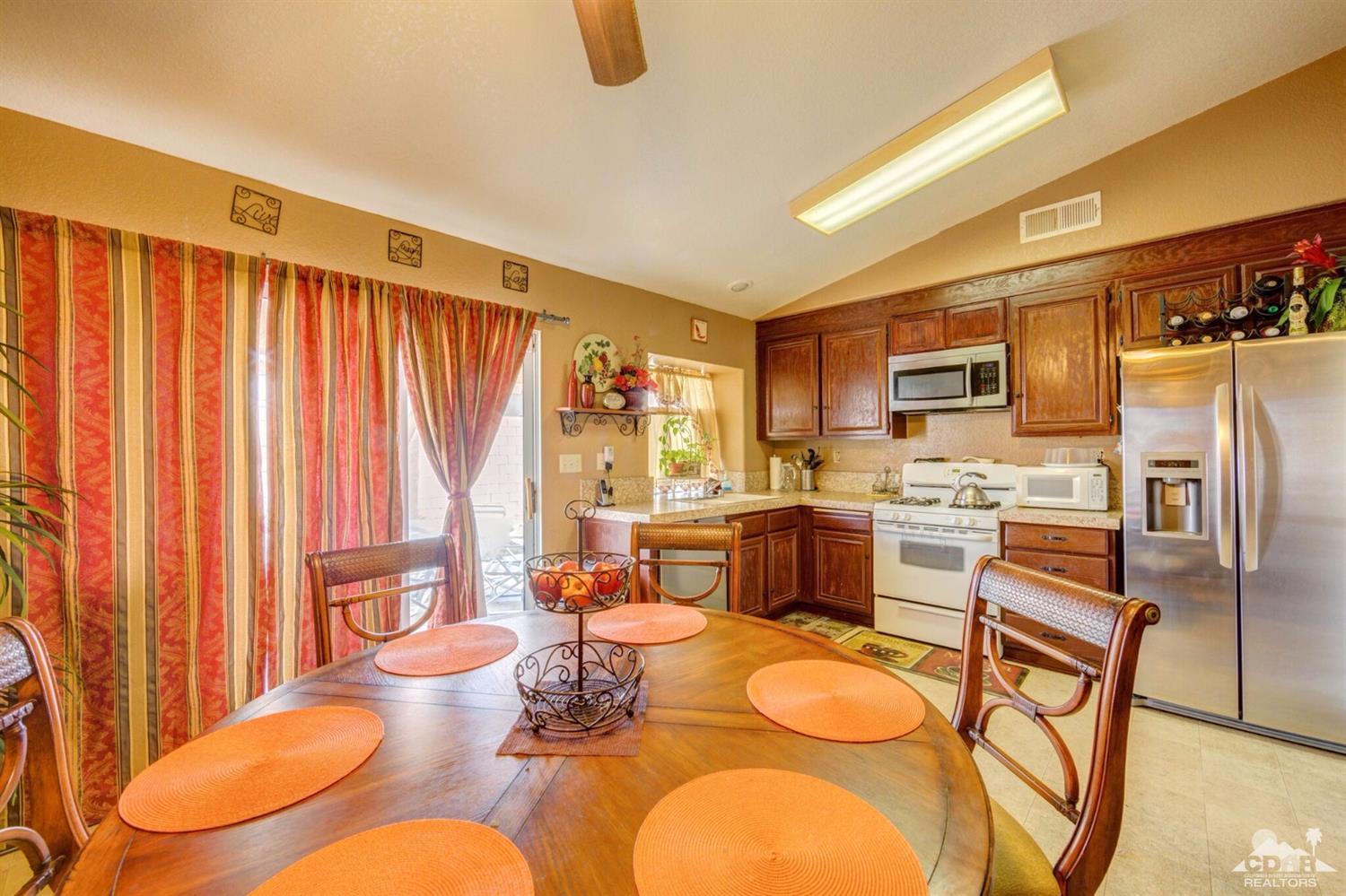 83948 Pacifica Sur Indio, CA 92203 - Photo 4 of 16 a living room with stainless steel appliances furniture a dining table and chairs