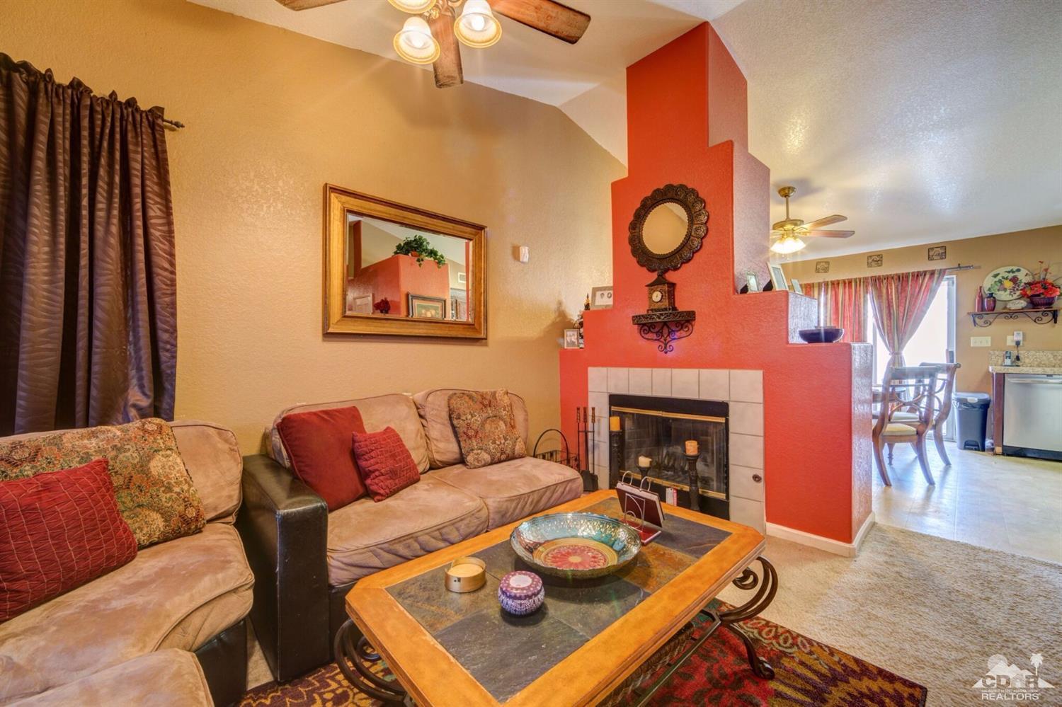 83948 Pacifica Sur Indio, CA 92203 - Photo 7 of 16 a living room with furniture a rug and a fireplace