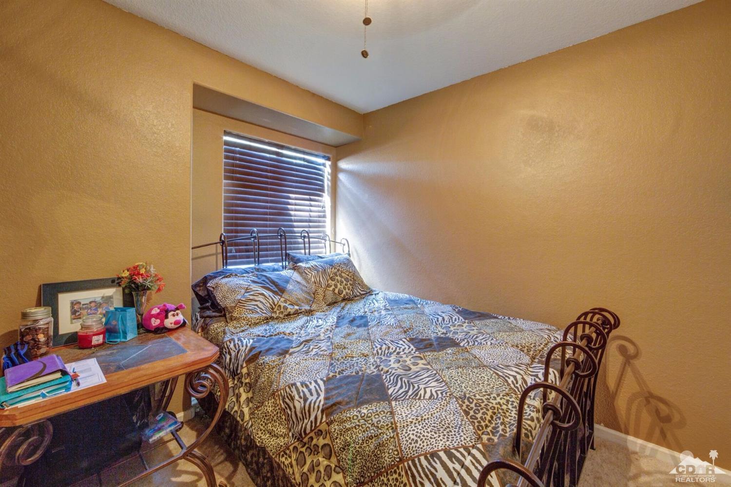 83948 Pacifica Sur Indio, CA 92203 - Photo 10 of 16 a bedroom with a bed and a window