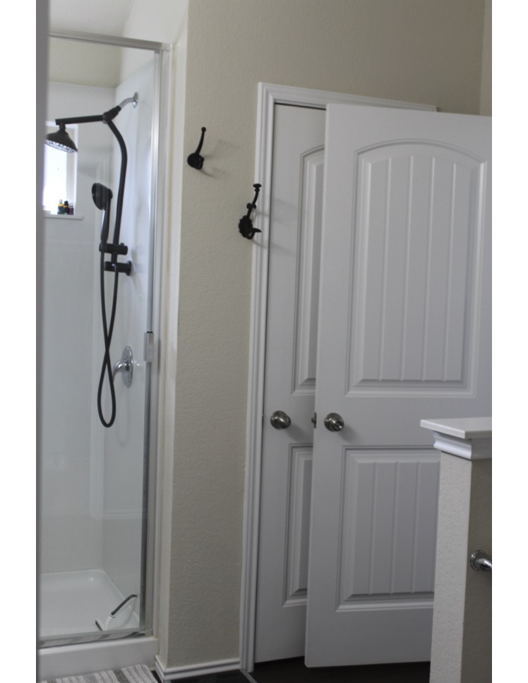 188 Beth Ann Loop Taylor, TX 76574 - Photo 7 of 12 A well-appointed shower stall with modern fixtures and a nearby door featuring classic paneling.