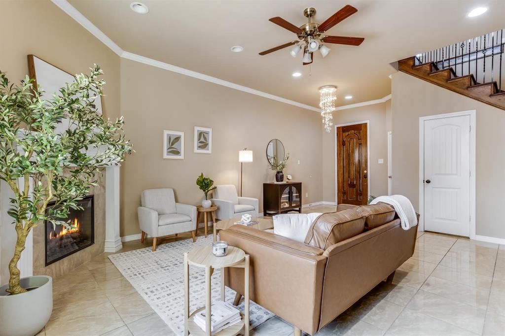 12364 Halima Street Dallas, TX 75243 - Photo 7 of 30 Vaulted ceiling with recessed lighting, tile flooring, built-in fireplace, wood staircase with iron balusters, and a decorative front entry door