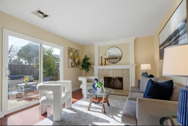 a living room with furniture a fireplace and a large window