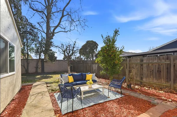 a backyard of a house with table and chairs