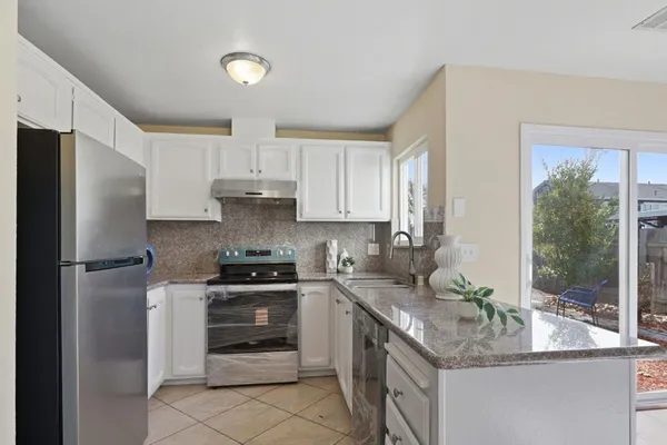 a kitchen with stainless steel appliances granite countertop a refrigerator and a stove