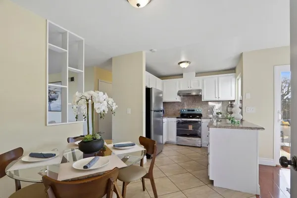 a kitchen with stainless steel appliances kitchen island granite countertop a table and chairs in it