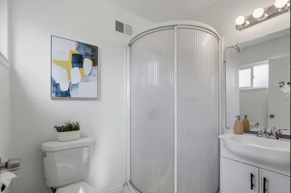 a bathroom with a toilet a sink and mirror