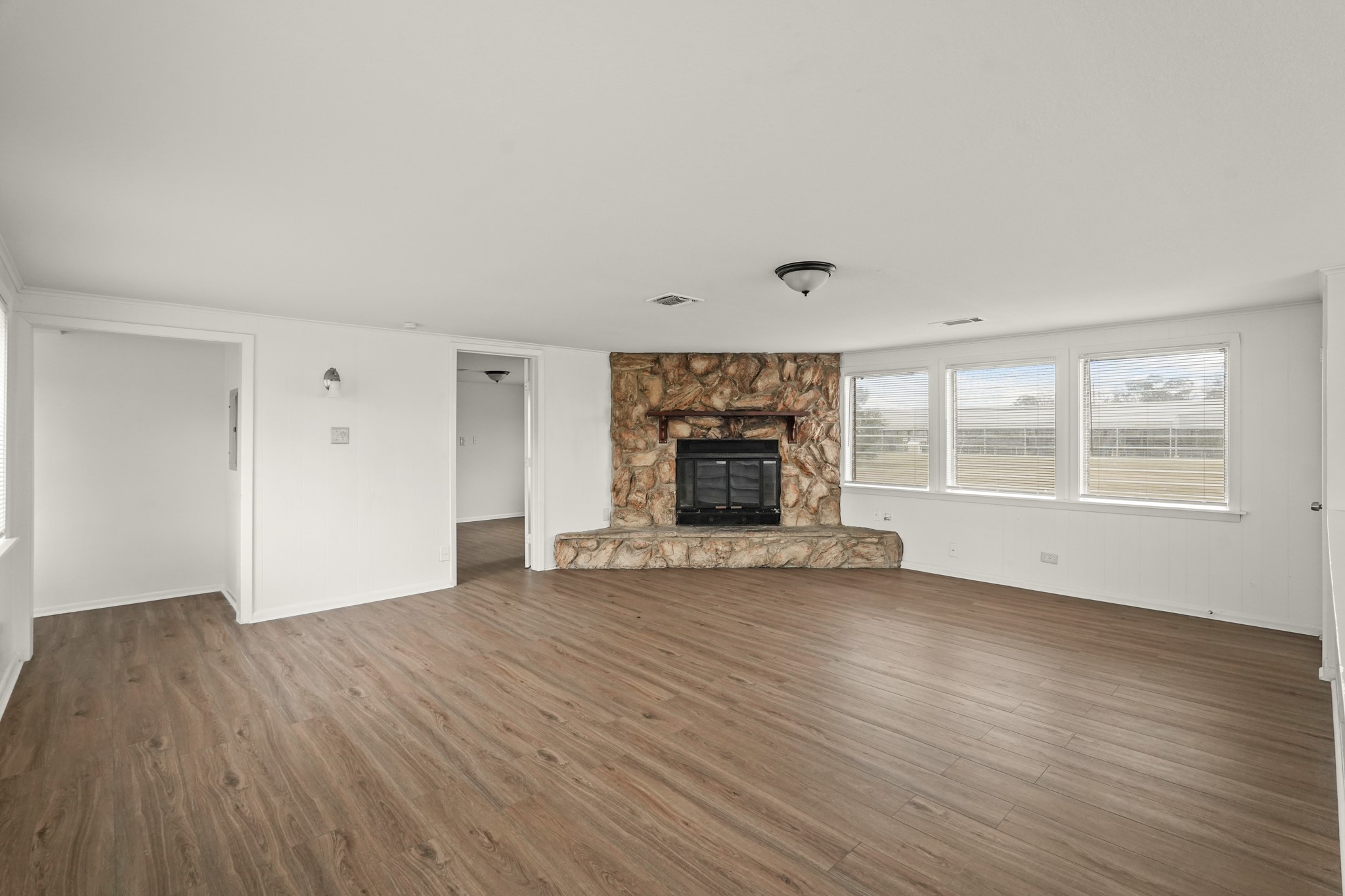 105 West Linney Street, Unit 3 Dayton, TX 77535 - Photo 3 of 12 an empty room with wooden floor fireplace and windows