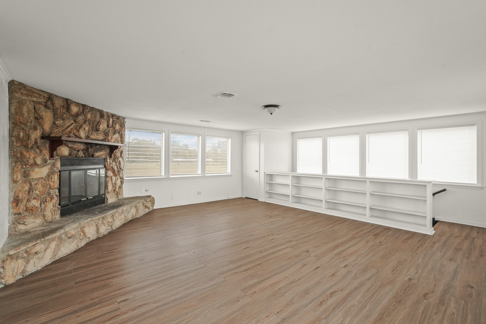 105 West Linney Street, Unit 3 Dayton, TX 77535 - Photo 4 of 12 an empty room with wooden floor fireplace and windows