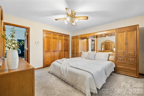a bedroom with a large bed and a chandelier