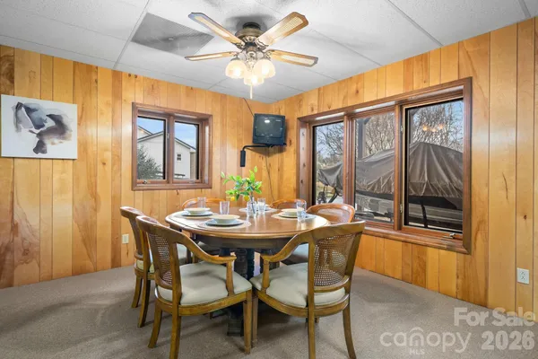 a view of a dining room with furniture and a chandelier fan