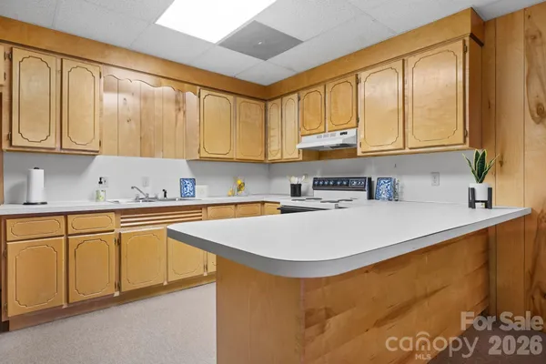 a kitchen with stainless steel appliances granite countertop a sink a stove and white cabinets