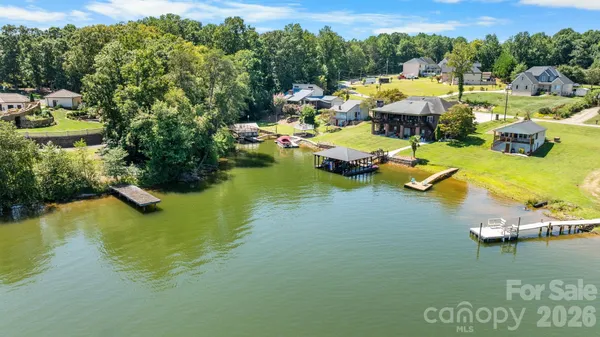 a view of swimming pool with outdoor seating lake view and trees in the background