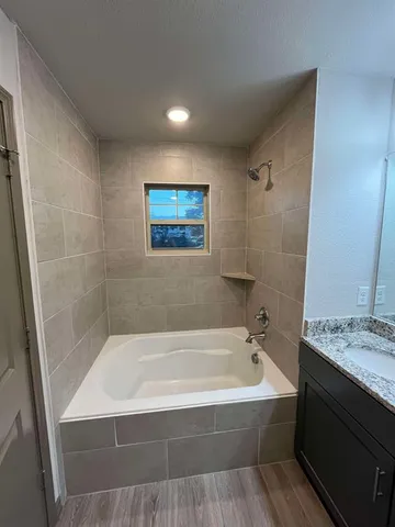 a bathroom with a tub a sink and a shower