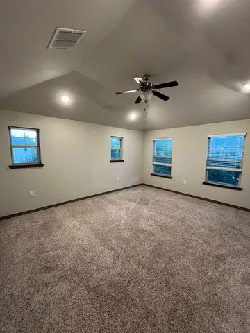an empty room with windows and fan