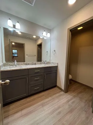 a spacious bathroom with a granite countertop sink and a mirror
