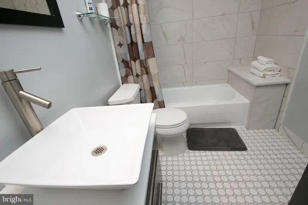 a bathroom with a sink a toilet and bathtub