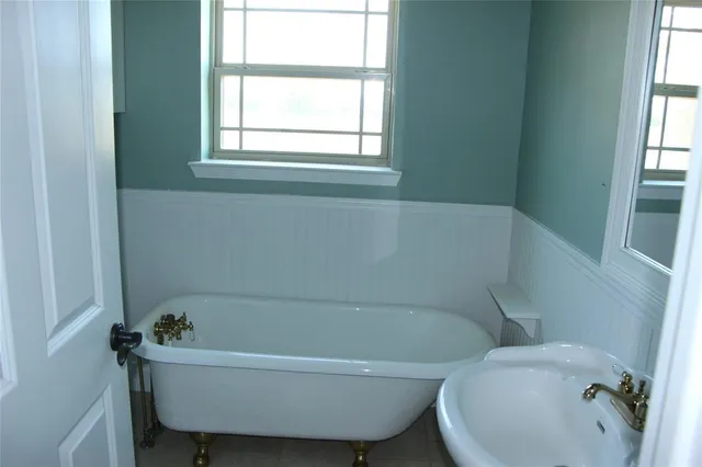 a bathroom with a tub and a window
