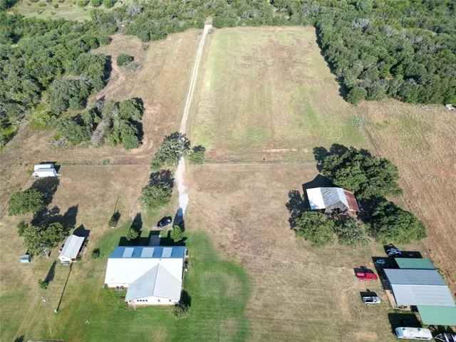 an aerial view of a house with a yard and trees