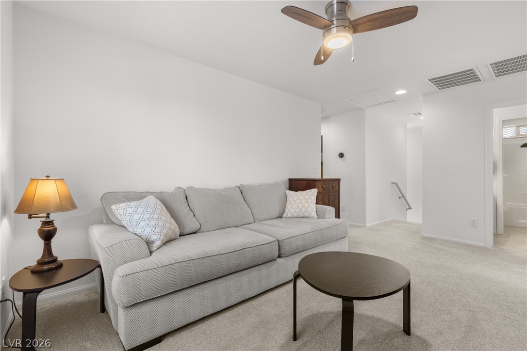 891 Earth Luster Road Las Vegas, NV 89178 - Photo 28 of 48 A comfortable living space featuring soft carpeted flooring and an overhead ceiling fan for optimal air circulation.
