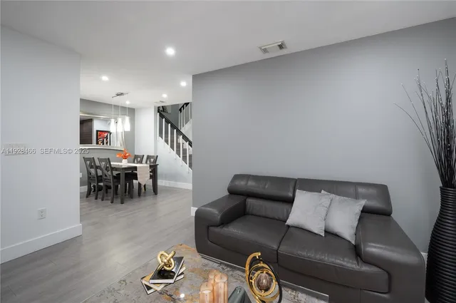 a living room with furniture and a wooden floor
