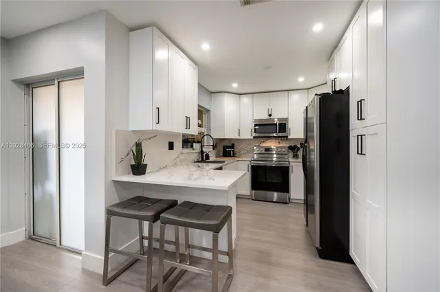 a kitchen with kitchen island a refrigerator stove and microwave