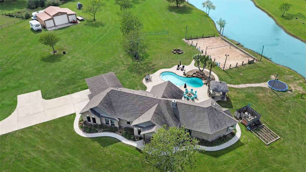 an aerial view of a house with backyard swimming pool and outdoor seating