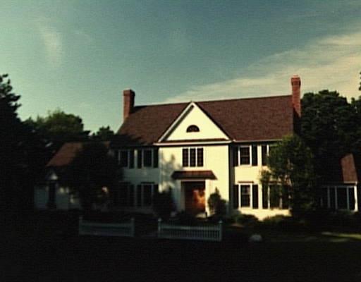 a view of a white house next to a yard