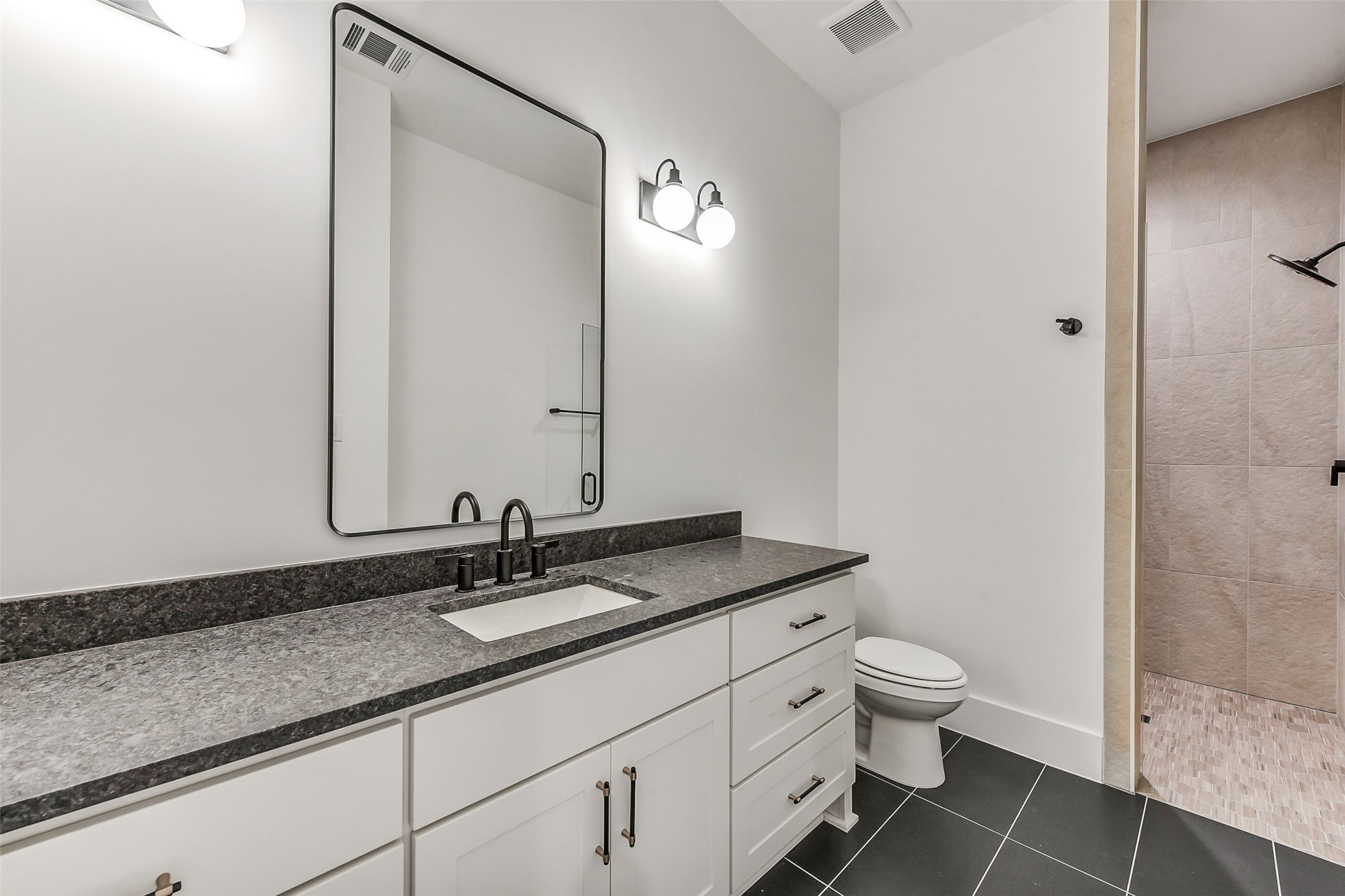1902 Nantucket Drive Houston, TX 77057 - Photo 49 of 50 a bathroom with a granite countertop sink a toilet and a mirror