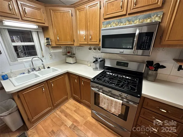 a kitchen with stainless steel appliances a stove a sink and a microwave